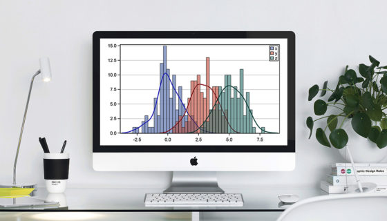 A chart displayed on a mac. Standing on a desk in an office.